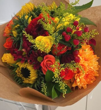 Deep blue thistles compliment bold Sunflowers with burst of orange Roses for a unique design. Next Day Delivery, Wickford, Essex, Hertfordshire.